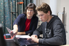 A woman gives a speech to all the graduating students. Links to Gifts from Retirement Plans A teacher helps a student with an assignment. Links to Gifts from Retirement Plans